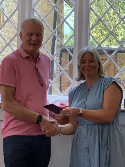 Paul, Who Burns Cakes receives the prize for the `highest championship game score from Elaine.